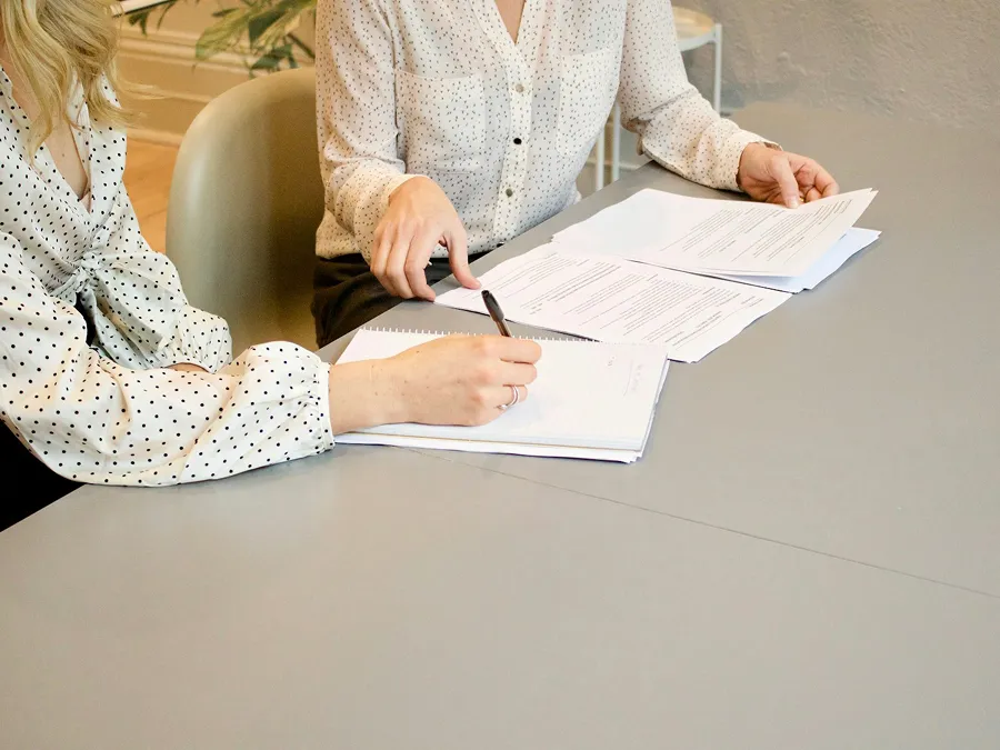 Two people signing papers