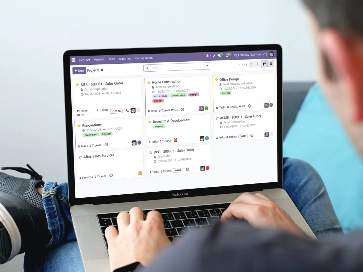 A man using his computer, with the main screen of the project management application visible